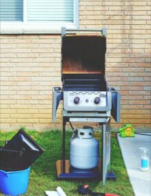 A BBQ set up to cook in a back garden