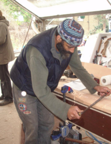 A man using traditional tools while woodworking at a bench